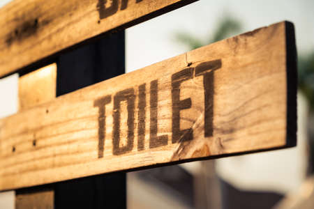 Closeup toilet sign made by wood plank on the post, outdoor toilet signの写真素材