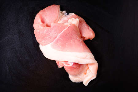 Closeup raw streaky pork or cutting part of fatty belly pork on black frying panの写真素材