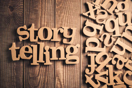 STORYTELLING words with random wood alphabets on wood backgroundの写真素材