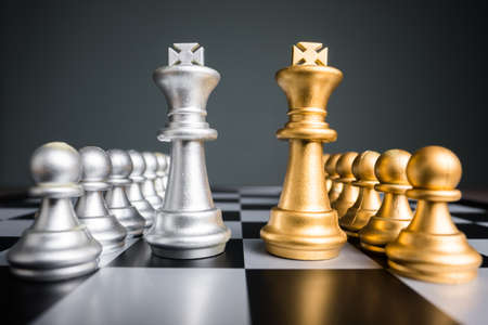 Silver and golden chess of kings and pawns in a row on the chess boardの写真素材