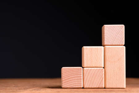 Wood block component as step stair on black background, business growth and goal conceptの写真素材