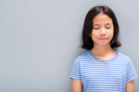 Little Thai girl in casual cloths standing and close her eyes to meditating and be calmの写真素材