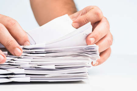 Closeup hand flipping the category paperwork on the pile to search  informationの写真素材