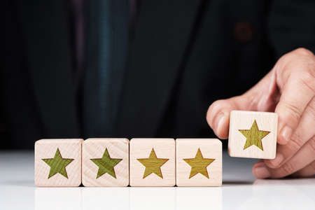 Closeup business man rate five stars score on wooden blocksの写真素材
