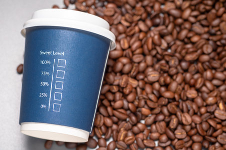 Sweet Level text with percentage and check box printed on portable cup with pile of coffee beans,...