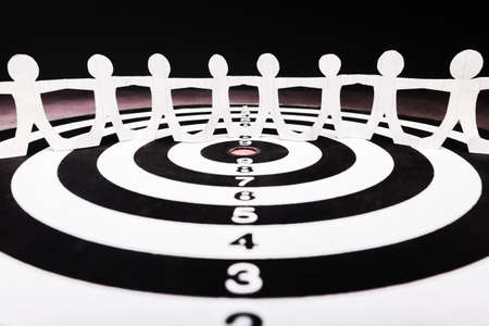 Paper human chain on target dartboard, human join together for one purpose, team and goal settingの写真素材