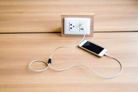 Smart phone charging battery by the usb charger socket built in on the top of the wood table