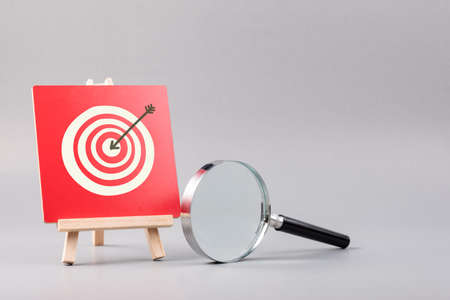 Magnifying glass and target accuracy on wood sign, business plan and marketing strategy, target customer conceptの写真素材