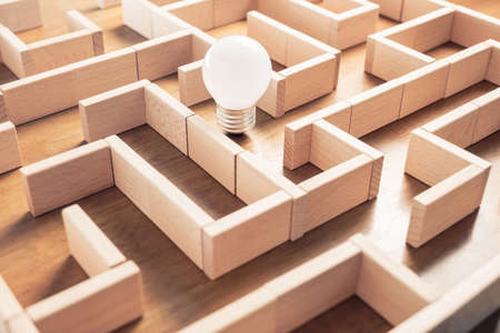 Light bulb in the labyrinth game set by wood blocks, find the right way to the exitの写真素材