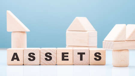 ASSETS wood blocks with wooden toy on the table, financial accounting, owned business resources conceptの写真素材