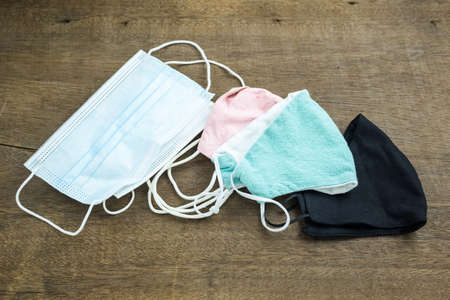Daily use face mask such as cloth mask and surgical face mask on wood tableの写真素材