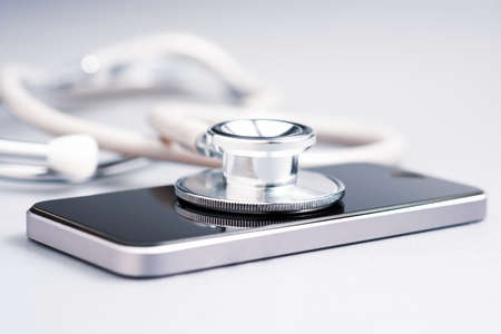 Closeup stethoscope placed on smart phone on the table, medical online service, telehealth,
