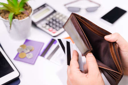 Closeup hand open the empty wallet with some credit cards in hand and placed on the desk, credit card debtの写真素材