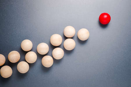 Different wooden red ball in higher position and lead the group of original wood ballsの写真素材