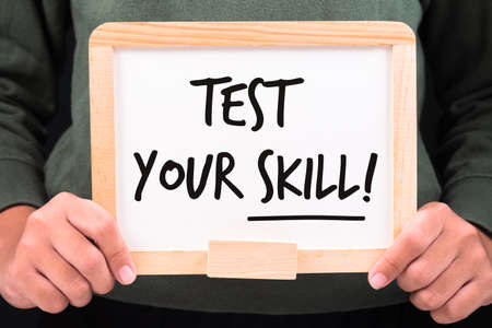 Closeup girl holding small whiteboard with text Test Your Skills