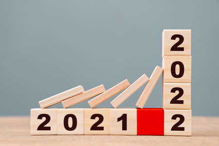 Concept for business plan in 2021 and 2022 built by wood blocks, domino fall down on 2021 and need to stop the impact in 2022の写真素材