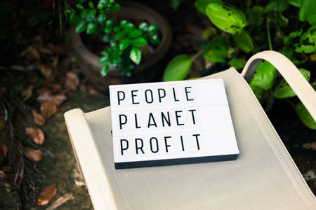 People, Planet, and Profit ; text on the advertising box sign left on the chair in the garden, sustainable development conceptの写真素材