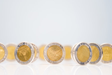 Money coins stand by the edge on glossy white surface, 10 Thai baht coins spread in many position as investment, or economic, and currency conceptの写真素材