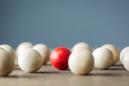 Noticable in the crowd, patined red ball in the group of wood ball, find the advantage in the high competitionの写真素材