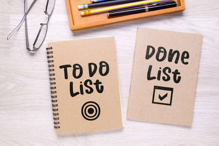 Two separated notebooks with text: To Do List and Done List, on the desk, as memo for tracking what...