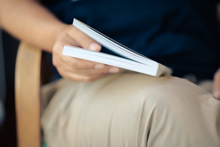 Closeup woman rest the book on her lap and bookmark the pages with fingerの写真素材
