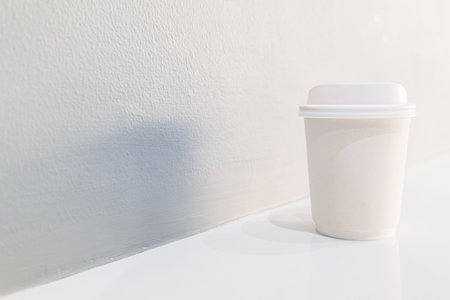 Takeaway white coffee cup on on gray wall with copy space for textの写真素材