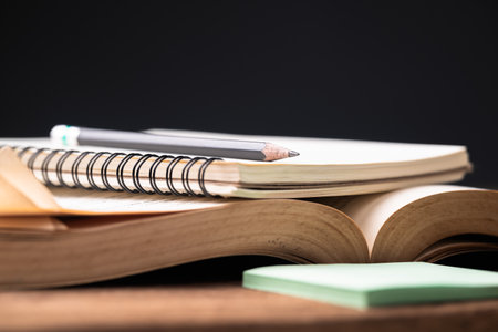 Closeup pencil and notebook above the opened old book, writing, take a note from the content in the bookの写真素材