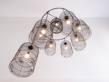 Electricity celing lamps designed as round bird cage hanged on the white celingの写真素材