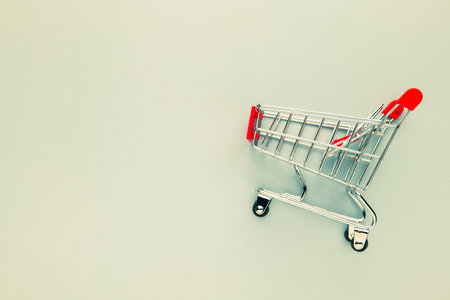 Miniature shopping cart on paper background with copy spaceの写真素材