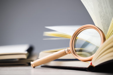Closeup magnifying glass lean on the page of the opened book, research information, glossary, education conceptの写真素材