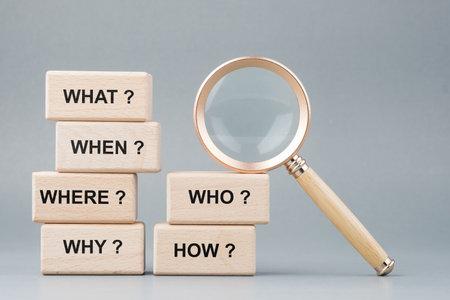 Qurstion words on stack of wood blocks with magnifying glass, questions analysis, investigation, test, quiz, or marketing, and FAQs conceptの写真素材