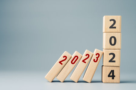 2023 domino effect ends at the 2024 stack wood cubes, new year solutions to stop the impact of 2023 finance, economic recessionの写真素材