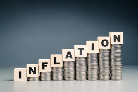 INFLATION word by wood cubes on the stack of money that is higher in each stepの写真素材