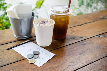 Closeup service tip on the receipt with some drinks on the tableの写真素材