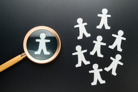 A man doll in focus, paper human symbol and magnifying glass, search the talent people, man replacementの写真素材