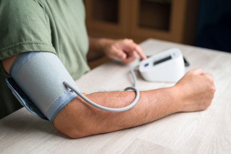 Closeup man measure blood pressure by blood pressure monitor at his own homeの写真素材