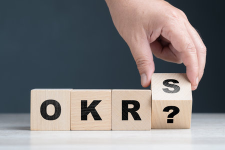 Closeup hand that flips the alphabet wood cubes, understanding of OKRs (Objective Key Results), what is OKRs conceptの写真素材