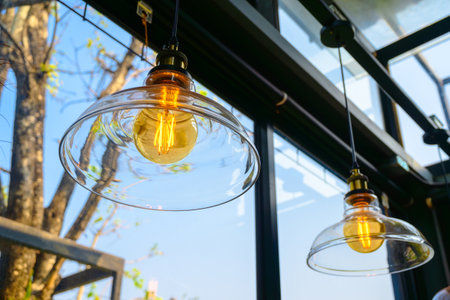 Glass bowl ceiling lamps in the glass room with tree and blue sky outsideの写真素材