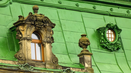 Green roof of an old building with windows.の写真素材