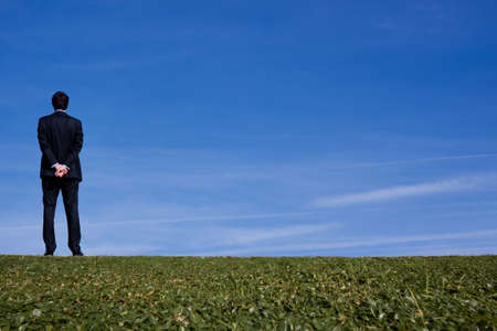 Tall business man outdoors looking off into the distanceの写真素材