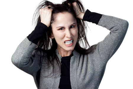 Woman pulling out her hair in frustration, isolated image