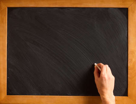 Male hand writing with chalk on a clean blackboard - add your own chalk!