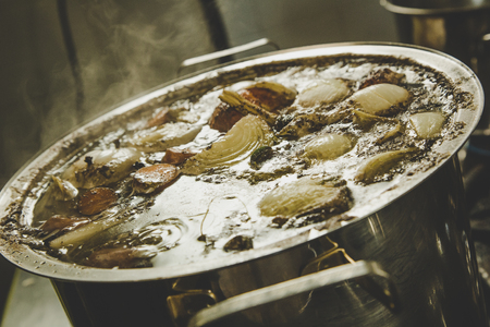 Beef broth boiling in a metal potの写真素材
