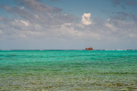 The turquoise sea of the reef with a shipwreck on the horizon line. San AndrÃ©s island, Colombia.の写真素材