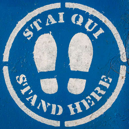 Social distance sign enamel painted with stencil on the floor