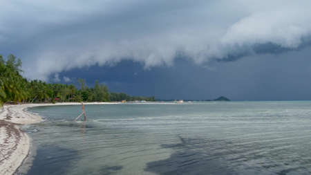 Waving blue sea, sandy shore of Samui Island during wet rain season, Thailand. Hurricane and storm...
