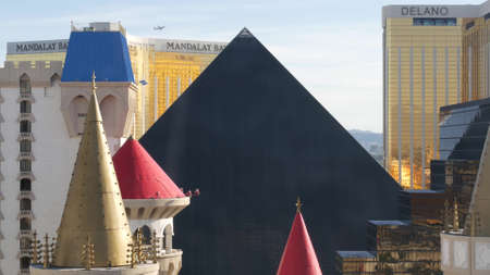 LAS VEGAS, NEVADA USA - 4 MAR 2020: Excalibur castle and Luxor pyramid casino uncommon aerial view. Plane flying from McCarran airport. Mandalay Bay and Delano hotel in american gambling sin city.のeditorial素材