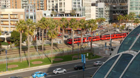 SAN DIEGO, CALIFORNIA USA - 30 JAN 2020: MTS red trolley and metropolis urban skyline, highrise...