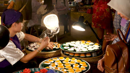 BANGKOK, THAILAND - 18 MARCH, 2019: Icon Siam shopping mall. Ethnic people choosing dishes of traditional Thai cuisine while standing near stalls of oriental asian night market food court.のeditorial素材