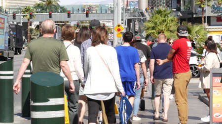 LAS VEGAS, NEVADA USA - 7 MAR 2020: People on pedestrian walkway. Multicultural men and women...